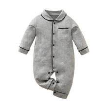 Load image into Gallery viewer, Gray baby onesie with buttons on a beige surface, accompanied by white sandals and a small camera.
